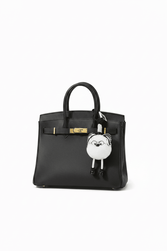 Fluffy Zebra Pom Pom Keychain on Black Birkin Bag - White Background