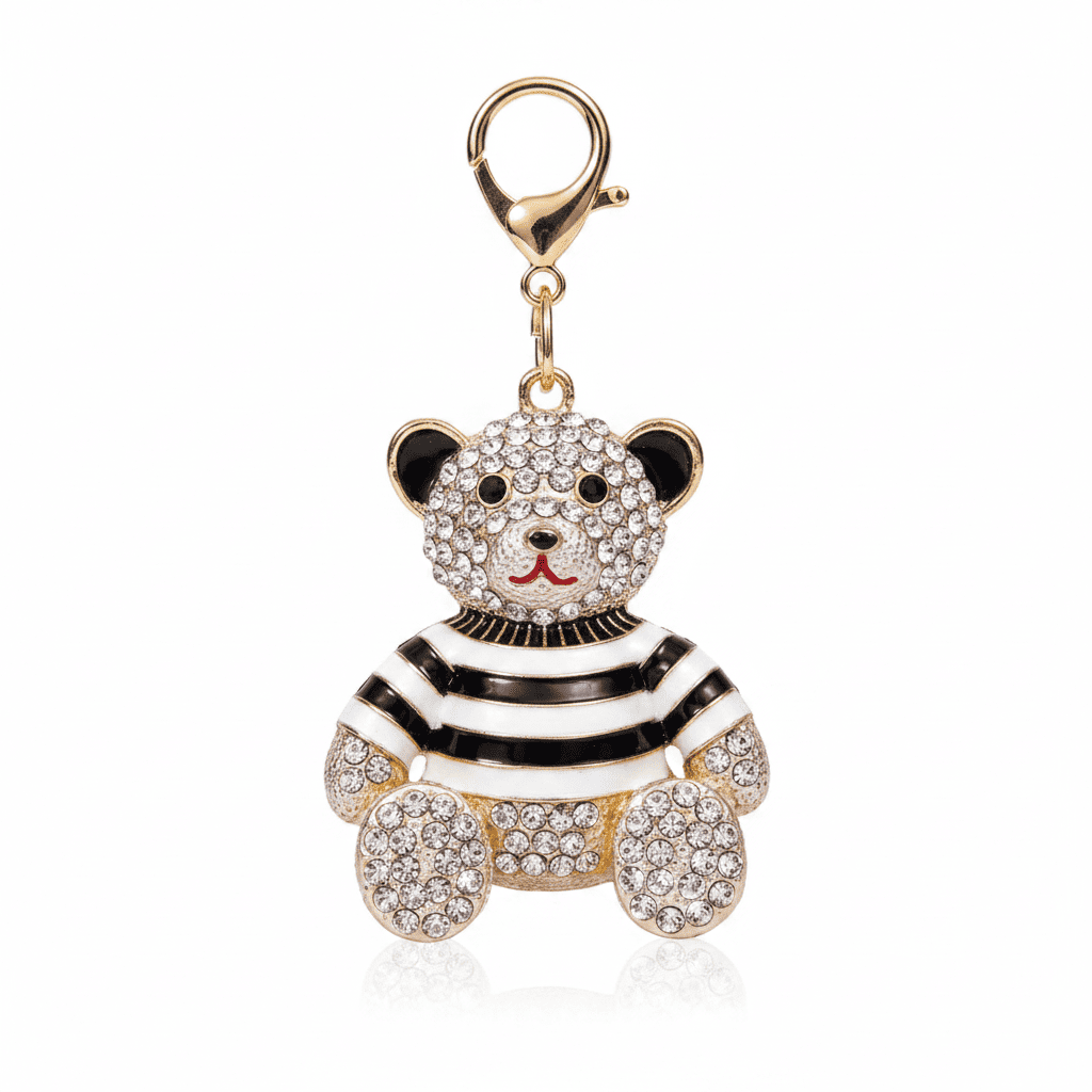 A rhinestone teddy bear charm in a striped or plaid enamel outfit