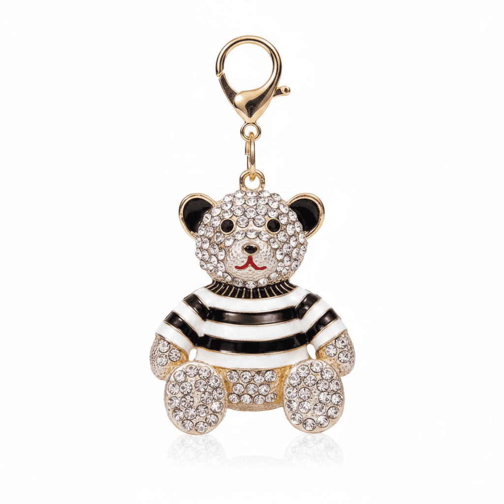 A rhinestone teddy bear charm in a striped or plaid enamel outfit