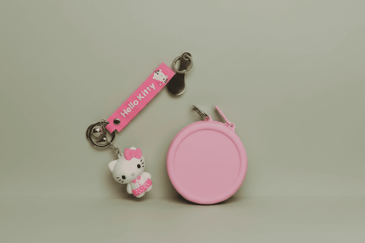 Pink Hello Kitty keychain and coin purse on a light gray background