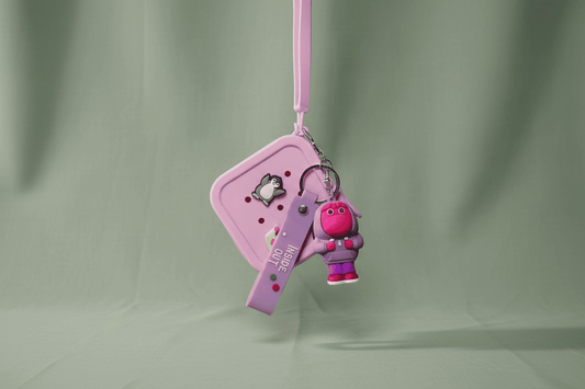 Pink keychain with a small character on a light green background