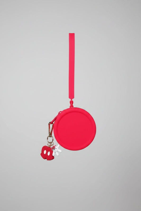 Red circular object with a charm on a textured white background