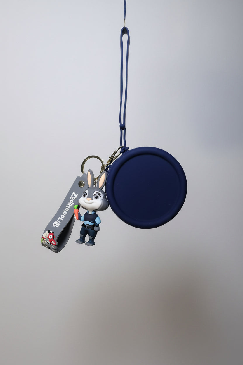 Keychain with a small round pouch and a character figure on a textured surface