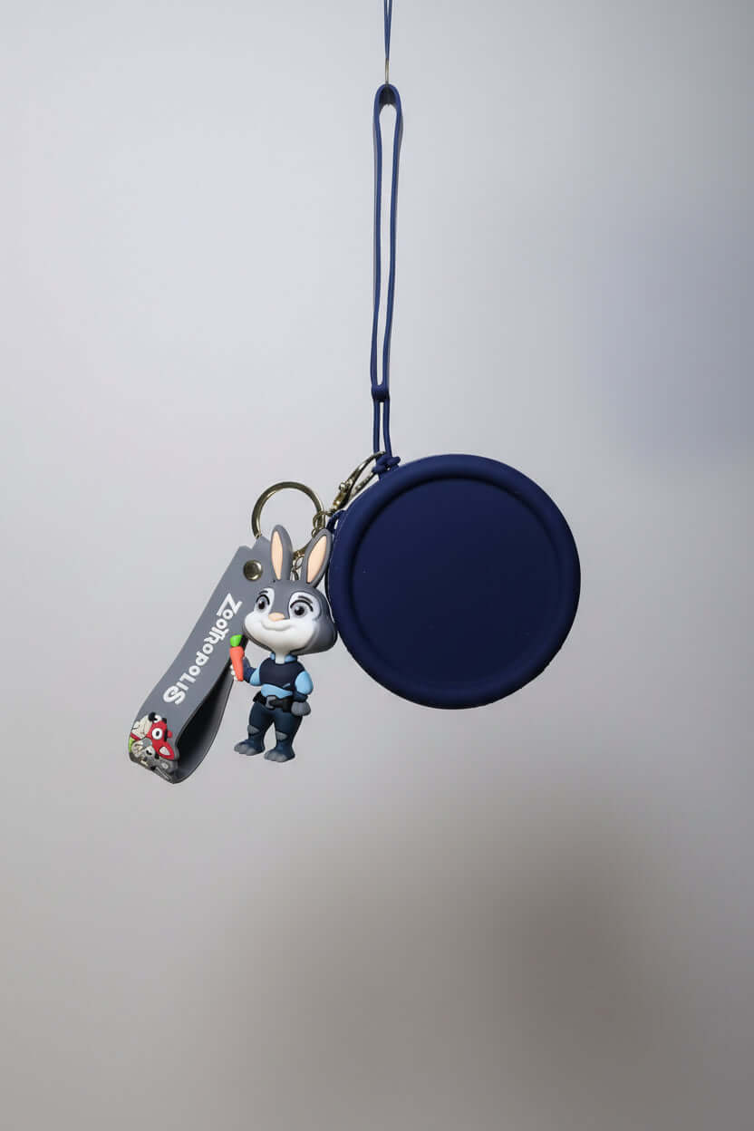 Keychain with a small round pouch and a character figure on a textured surface