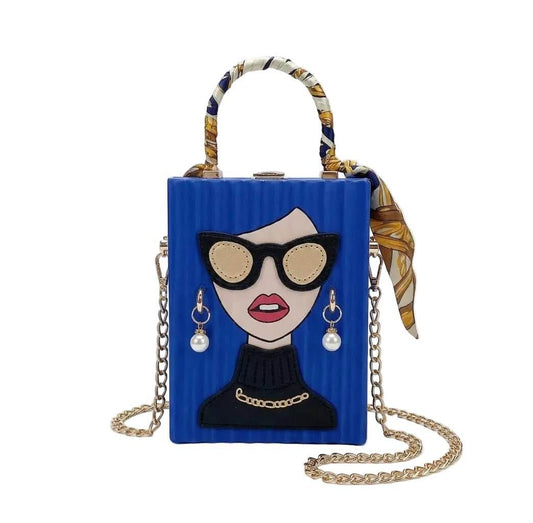 Blue handbag with a face design, sunglasses, and jewelry on a white background