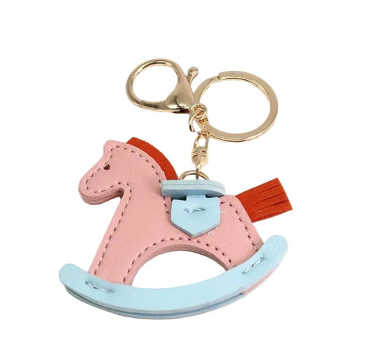 Pink and blue rocking horse keychain on a white background