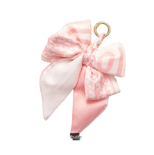 Pink butterfly-style scrunchie on a textured white background