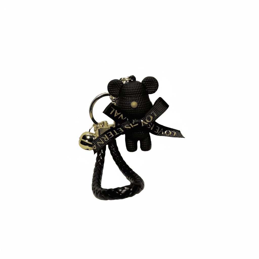 Black teddy bear keychain with a gold tag on a white background
