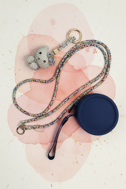 Crystal cat charm, rhinestone lanyard and navy coin purse on painted background