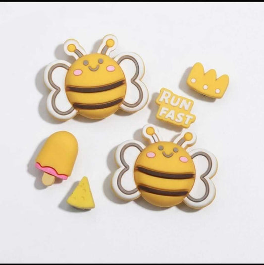 Set of cartoon bee-shaped items with a crown, ice cream, and triangle on a white background