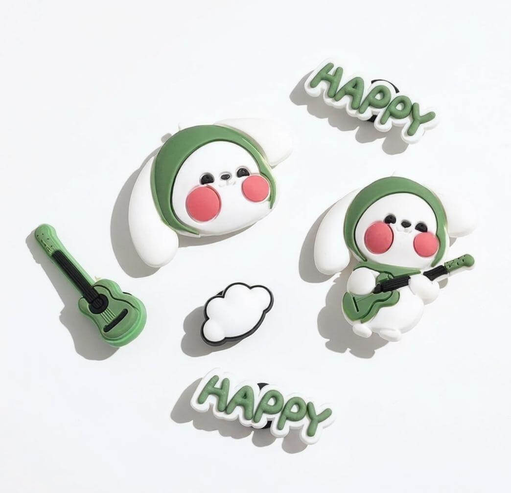 Two cartoon characters with green hats and pink cheeks, playing guitars, on a white background with 'Happy' text.