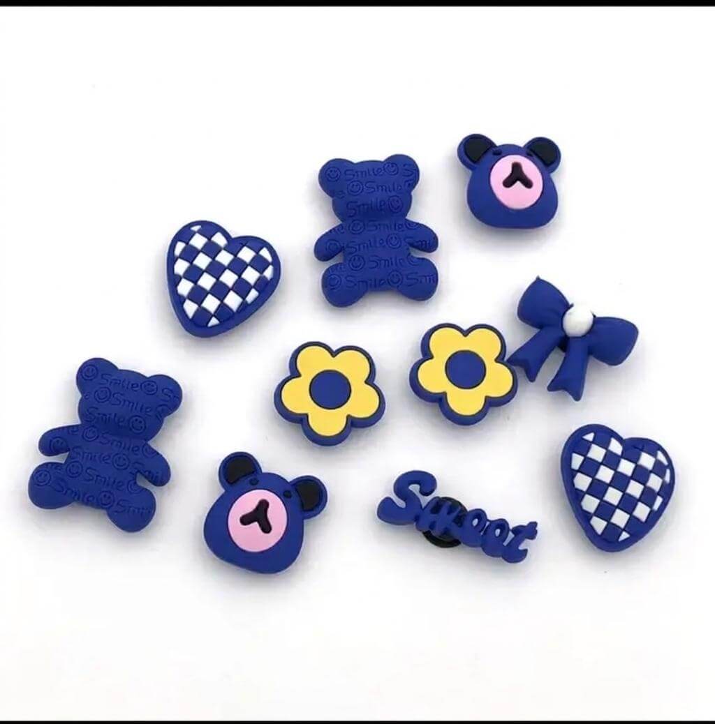 Collection of blue decorative items including teddy bears, flowers, and checkered hearts on a white background.