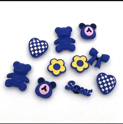 Collection of blue decorative items including teddy bears, flowers, and checkered hearts on a white background.