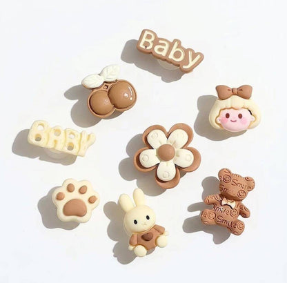 Set of baby-themed decorative items including a flower, bear, rabbit, and text on a white background.