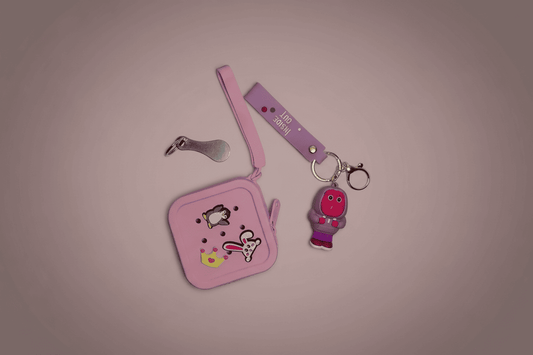 Pink pouch with cartoon character design and a keychain on a pink background