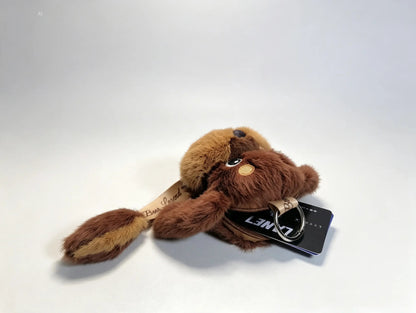 A plush dog keychain in shades of brown and tan, featuring a black metal keyring.