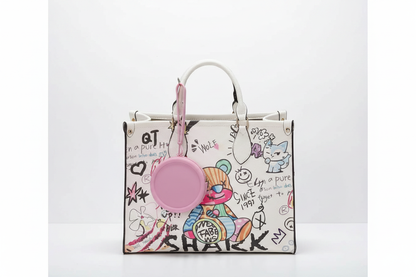 Pink coin purse dangling from graffiti tote bag