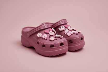 Pink kawaii shoe charms on dark pink clogs, dusty pink background