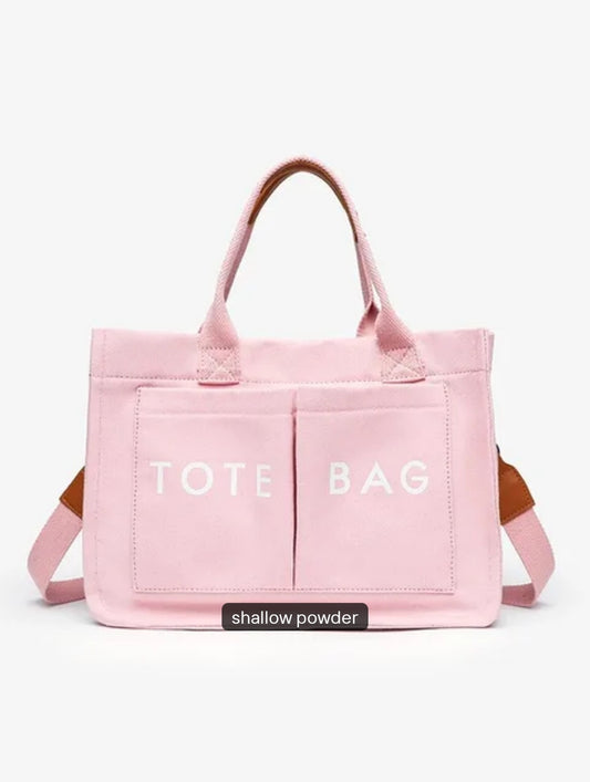 Pink tote bag with 'TOTE BAG' text on a white background