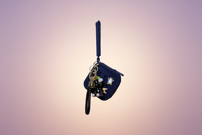 Small blue pouch with decorative charms on a gradient background