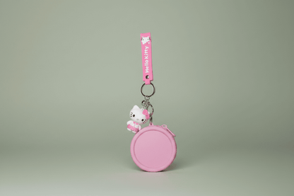 Pink keychain with a character on a light gray background