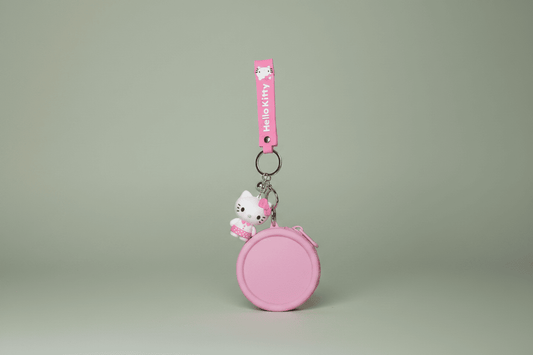 Pink keychain with a character on a light gray background