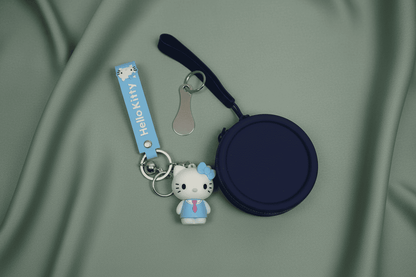 Navy blue keychain with Hello Kitty figure and coin purse on a green fabric background