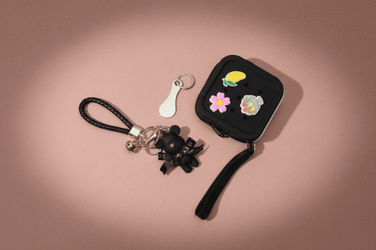 Black keychain with decorative elements on a pink background
