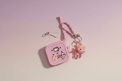 Pink keychain pouch with cartoon character charm on a pink background