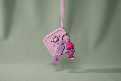 Pink keychain with a small character on a light green background
