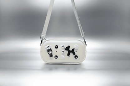 White handbag with black and white dog illustrations on a gray background