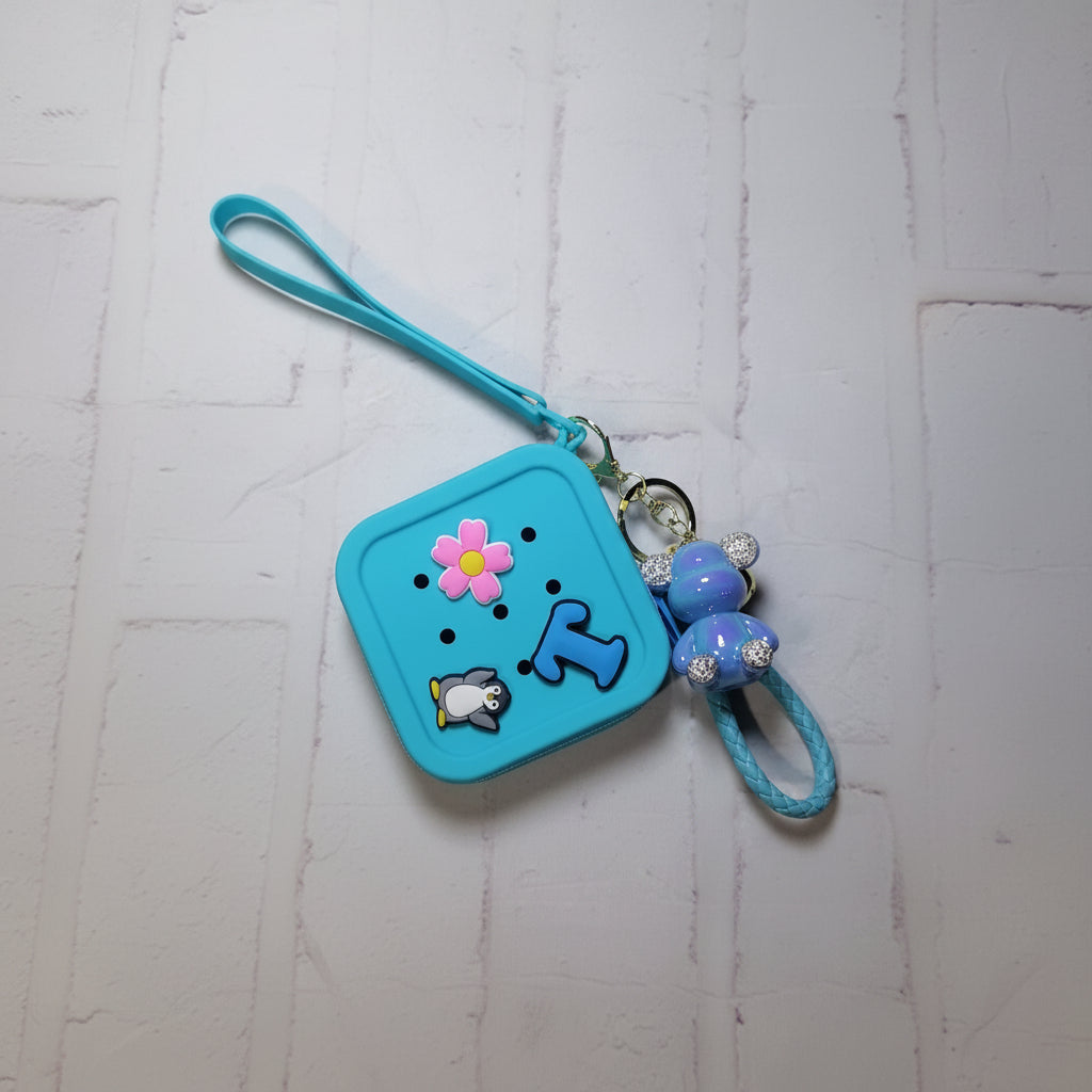 Blue coinpurse and keyring with cartoon characters on a textured white background
